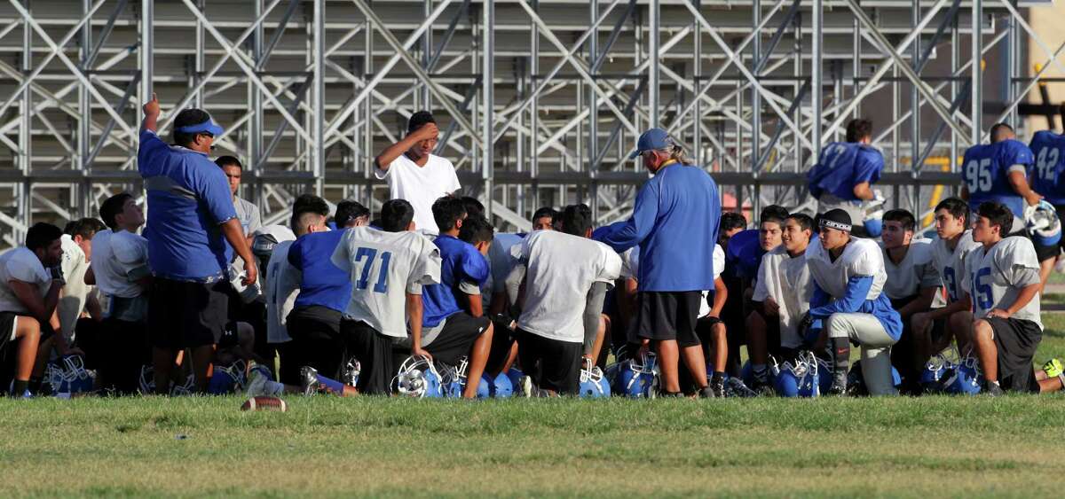 John Jay High School football coach Gary Gutierrez, standing at left, talks to players Tuesday afternoon, Sept. 8, 2015 during the first practice since two of their varsity players, Victor Rojas and Mike Moreno, were suspended indefinitely, pending investigation, over violently hitting a referee at the end of last Friday's road game in Marble Falls.