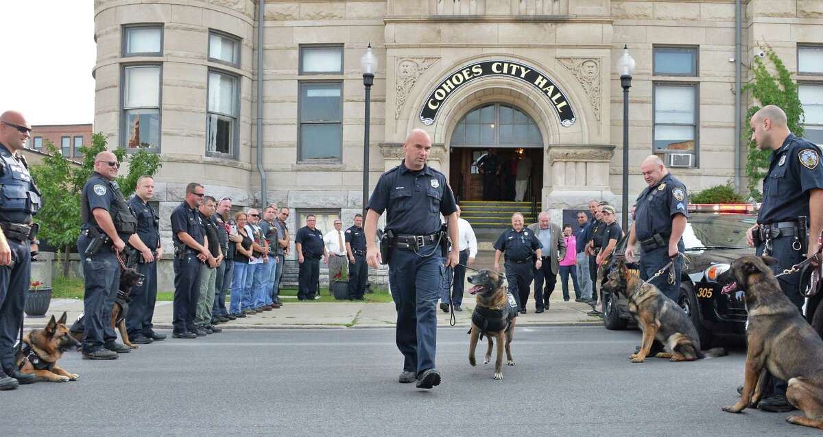 Officer and K-9 handler Sean McKown, center, walks K-9 Jeter out of the Cohoes Police Station on his final day of work Wednesday Sept. 9, 2015 in Cohoes, NY. (John Carl D'Annibale / Times Union)