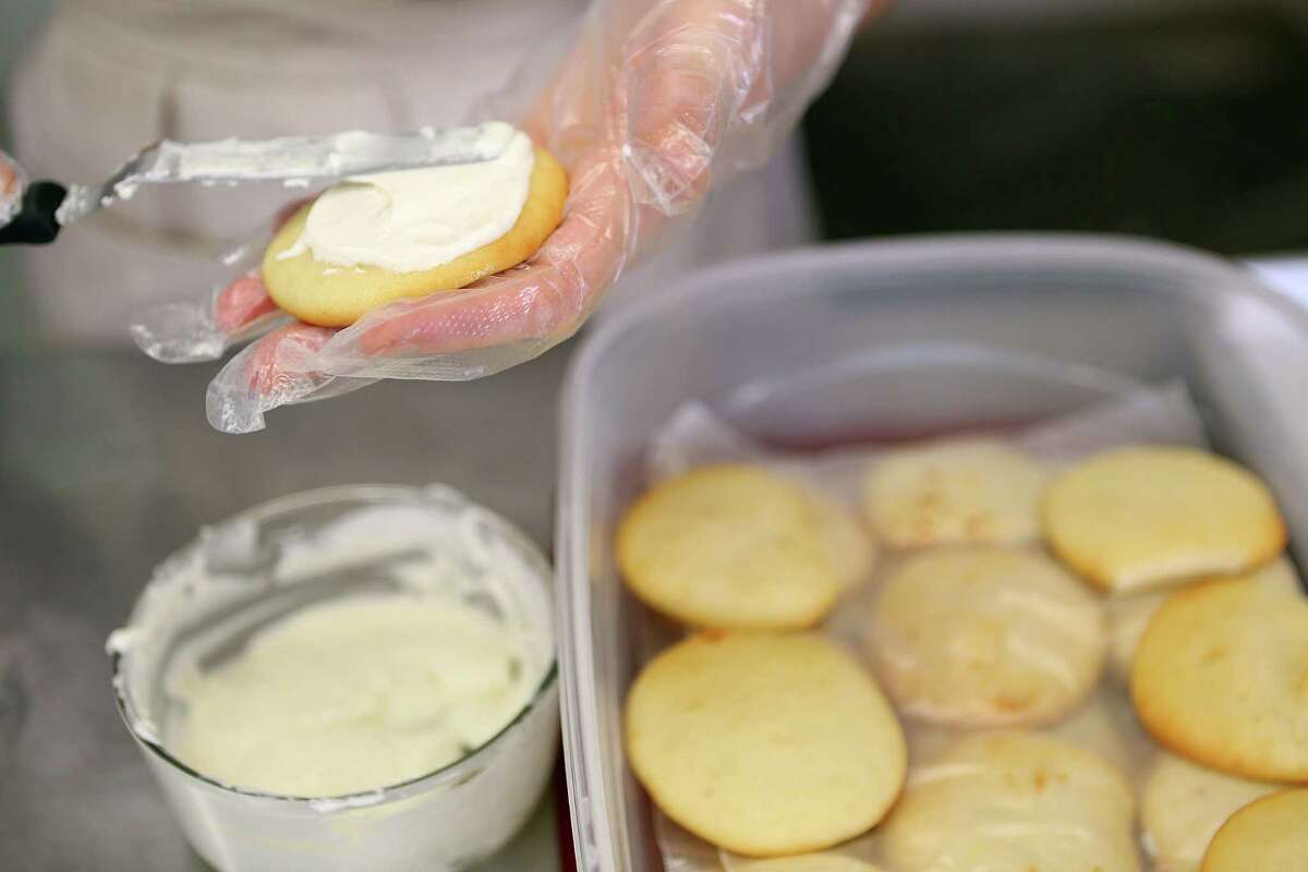 Jacquie Frnka, chef and owner of MargieBeth's Bake Shop, spreads icing on a batch of cookies.  Frnka was a nurse when she decided to change careers and open her own bakery.