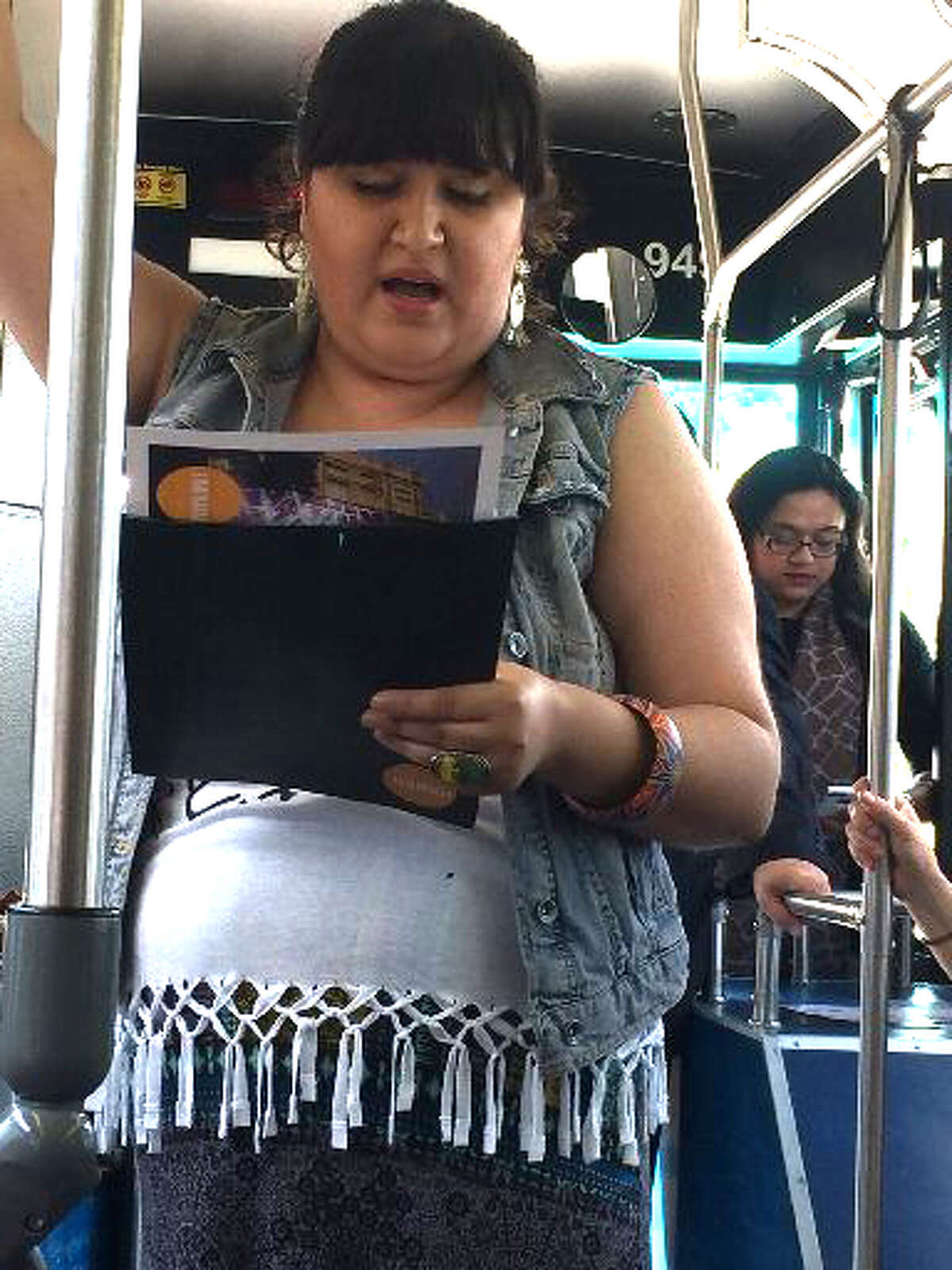 Bianca Sapet studies the lyrics for a song she was preparing to sing during a bus tour of the footprint for this year's Luminaria.
