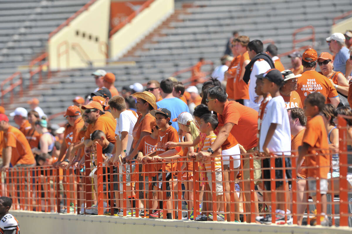 Longhorns football fans line the rail to watch a free, open-to-the-public practice at Royal-Memorial Stadium in Austin in 2013.