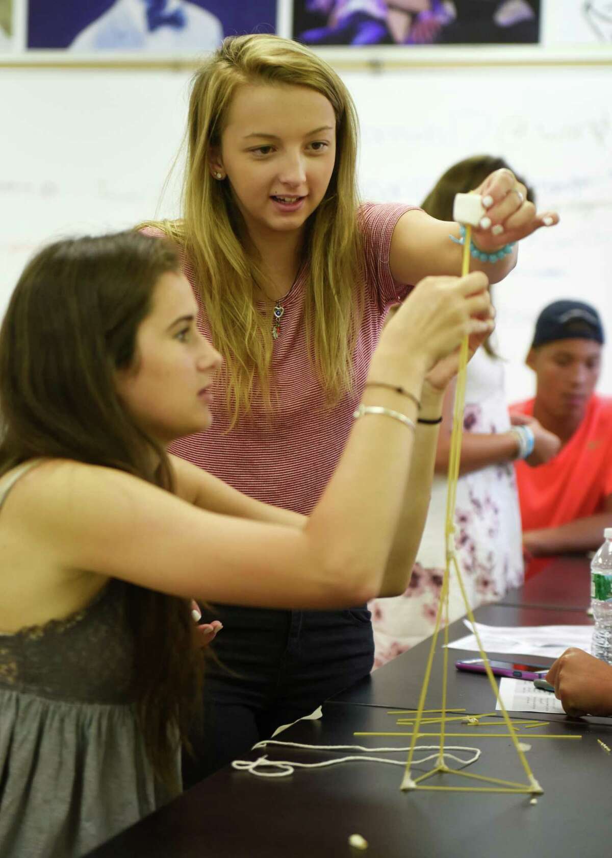 Sophomores Sofia Dodaro, left, and Fjolla Gashi attempt to build a tower out of spaghetti, tape and a single marshmallow during their Innovation Lab class at Greenwich High School in Greenwich, Conn. Thursday, Sept. 3, 2015.