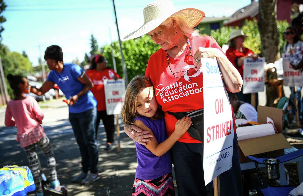 Marletta Iwasyk, a 47-year veteran teacher, comforts Esme Oehl, 6, who was upset that day one of first grade did not happen. Iwasyk, who participated in Seattle Public Schools last strike 30 years ago, was walking the picket line at Orca K-8 in south Seattle. Photographed on Wednesday, September 9, 2015.