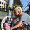 Margaret Partyka of Albany puts a new boa in the spokes of a ghost bike, Monday Oct. 10, 2011, in memory of the late Diva DeLoayza who was killed while riding a bike near the University Plaza in Albany, N.Y. Partyka owns the boutique Some Girls which was previously owned by DeLoayza. (Lori Van Buren / Times Union) ORG XMIT: MER2015090913422818