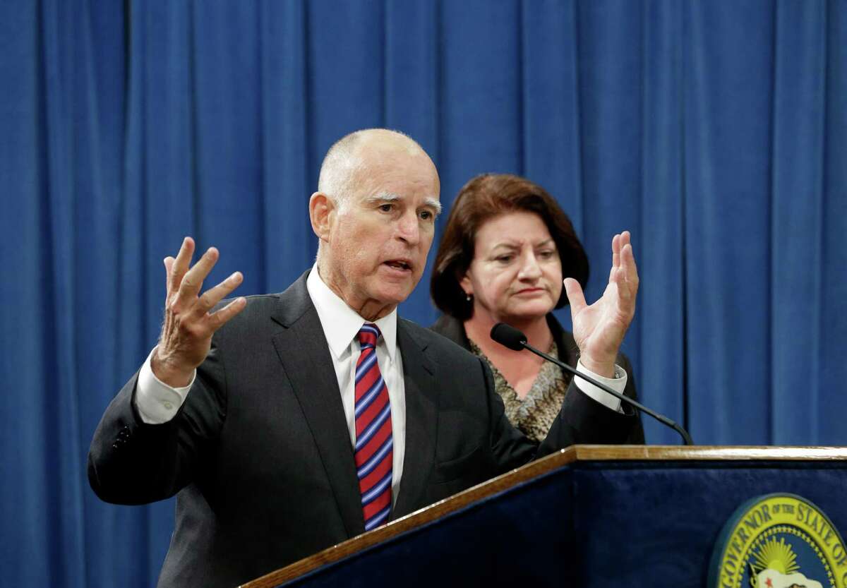 Calif. Gov. Jerry Brown, flanked by Assembly Speaker Toni Atkins, D-San Diego, right, announce that they are scaling back a proposal to address climate change, during a news conference, Wednesday, Sept. 9, 2015, in Sacramento, Calif. Citing opposition from the oil industry, de Leon said he was dropping a mandate in his bill, SB350, that the state cut petroleum use by 50 percent.
