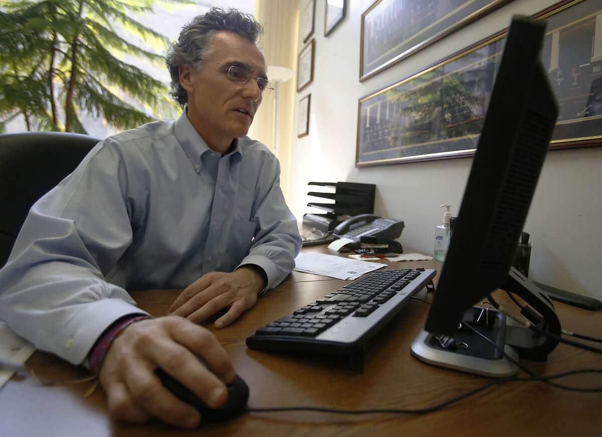 Thomas Dart, sheriff of Cook County, Ill., looks at computer screen in an office at his Chicago headquarters on Thursday, July 23, 2015. For years, Dart has been taking aim at Backpage.com, a classified ad website with an adult services section that has been shown in court to be used by sex traffickers - some who've sold minors for sex. (AP Photo/Martha Irvine)