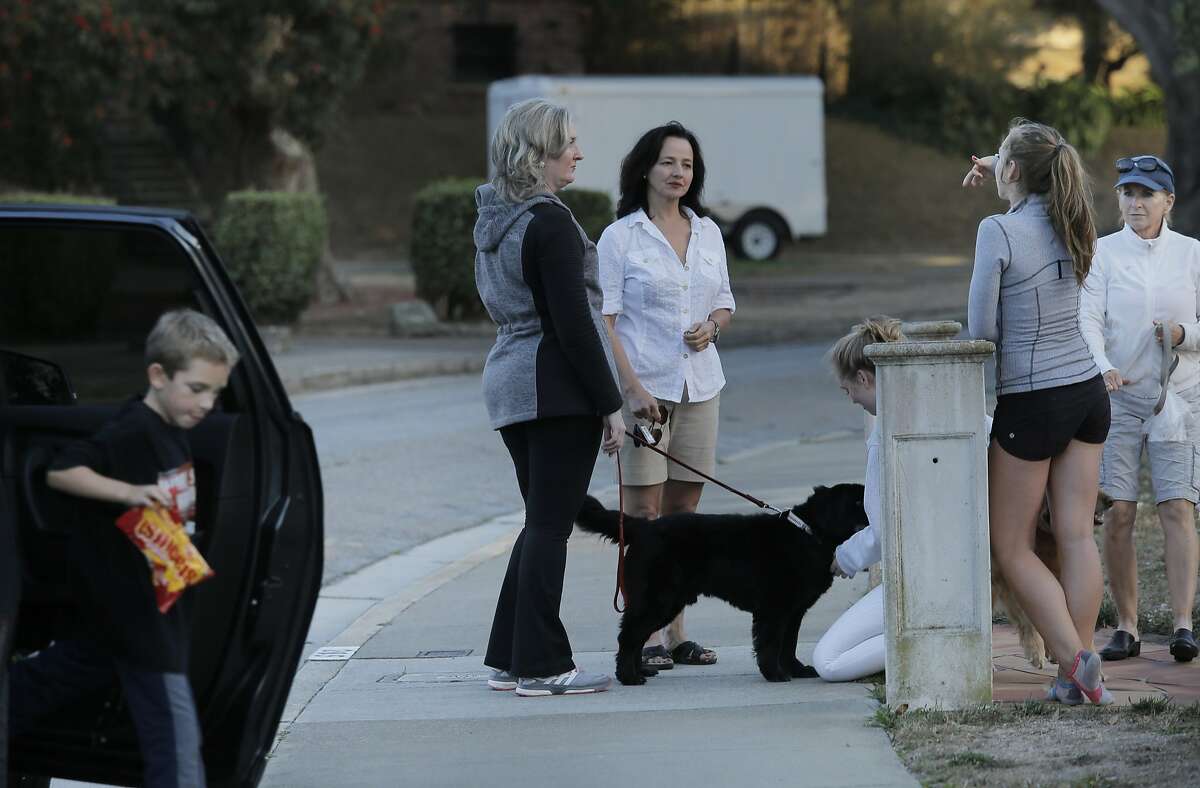Mary Paglieri, a coyote expert for the Little Blue Society, center (white shirt) talks with neighbors as she investigates reports of a pack of coyotes scaring residents of the Ingleside Terraces neighborhood in San Francisco, Cali., on Thursday, September 10, 2015. 