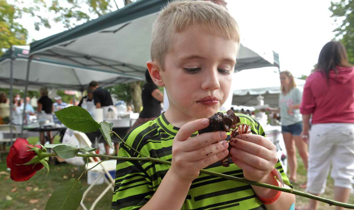 James Tong, 6, of New Milford, digs into a chocolate cupcake from The Sweet Spot, at the 10th annual Taste of New Milford on the Village Green Wednesday night.