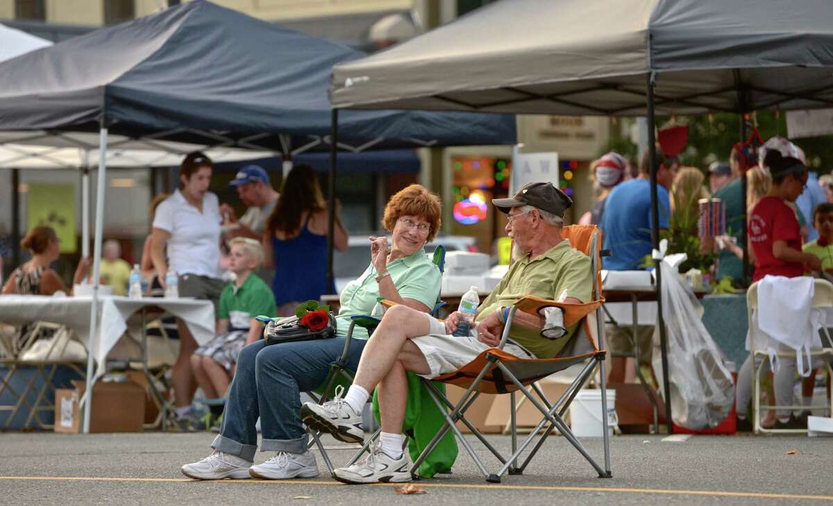 Chris and Mary Prause, of New Milford, sit in the middle of Church Street and listen to the band SongHorse during the Taste of New Milford.