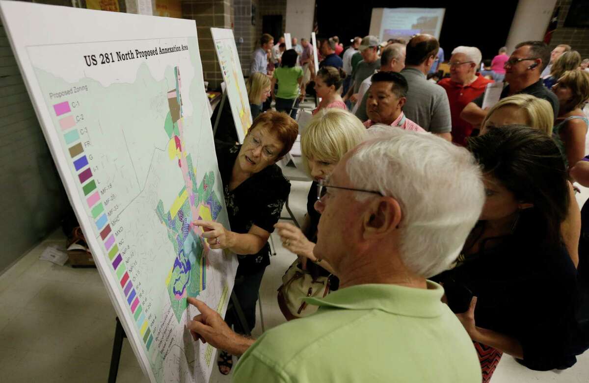 City of San Antonio senior planner Margaret Pahl points at a map while attempting to field questions at an “open house” as the city considered annexing five large sections of unincorporated Bexar County.