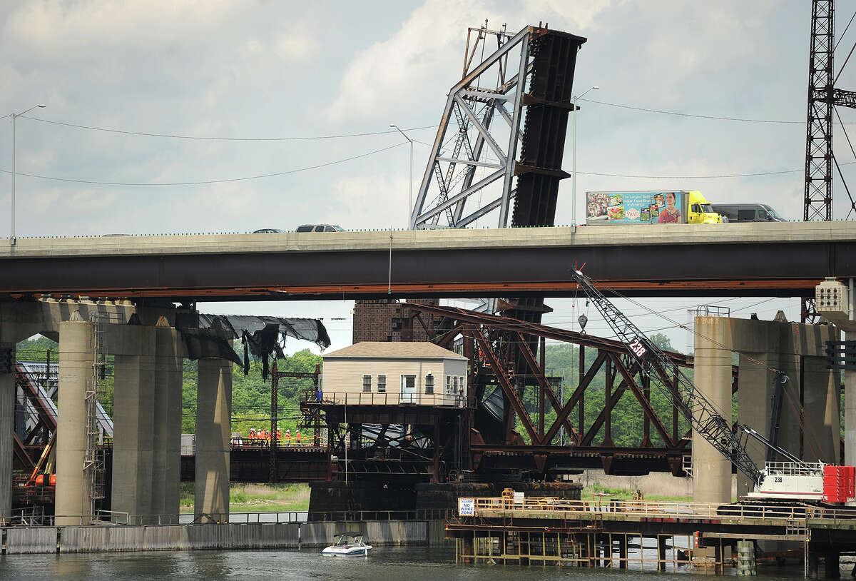 A train makes its way southbound as the northbound section of the Metro-North bridge across the Housatonic River between Stratford and Milford is stuck in the raised position on Thursday, July 2, 2015.
