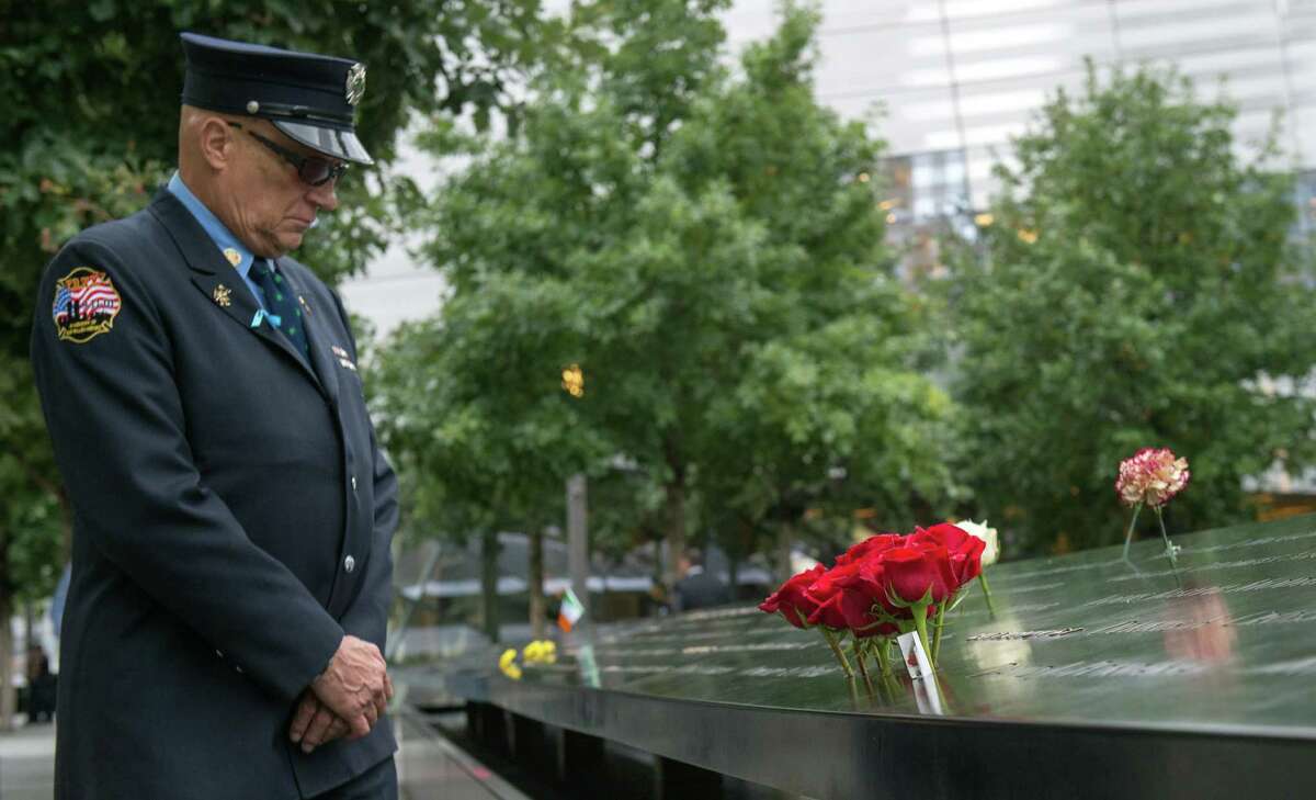Retired New York City firefighter Joseph McCormick visits the South Pool prior to a ceremony at the World Trade Center site in New York on Friday, Sept. 11, 2015. With a moment of silence and somber reading of names, victims' relatives began marking the 14th anniversary of Sept. 11 in a subdued gathering Friday at ground zero. (AP Photo/Bryan R. Smith)