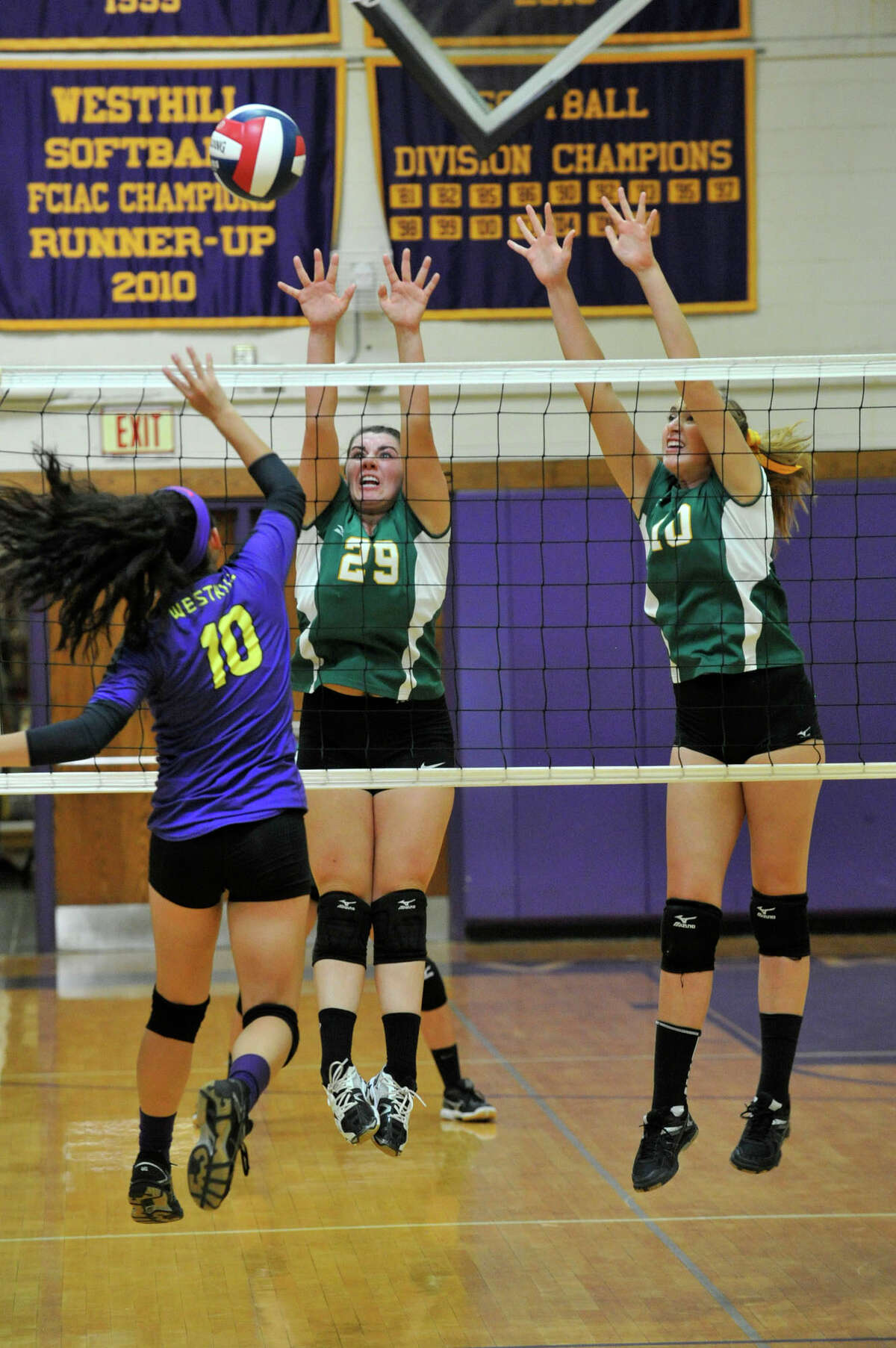 Westhill's Silvana Cardona hits the ball over a leaping Leah Zarrilli (29) and Emily Ellis of Trinity Catholic during their volleyball match at Westhill High School in Stamford on Friday. Trinity Catholic won 3-0.