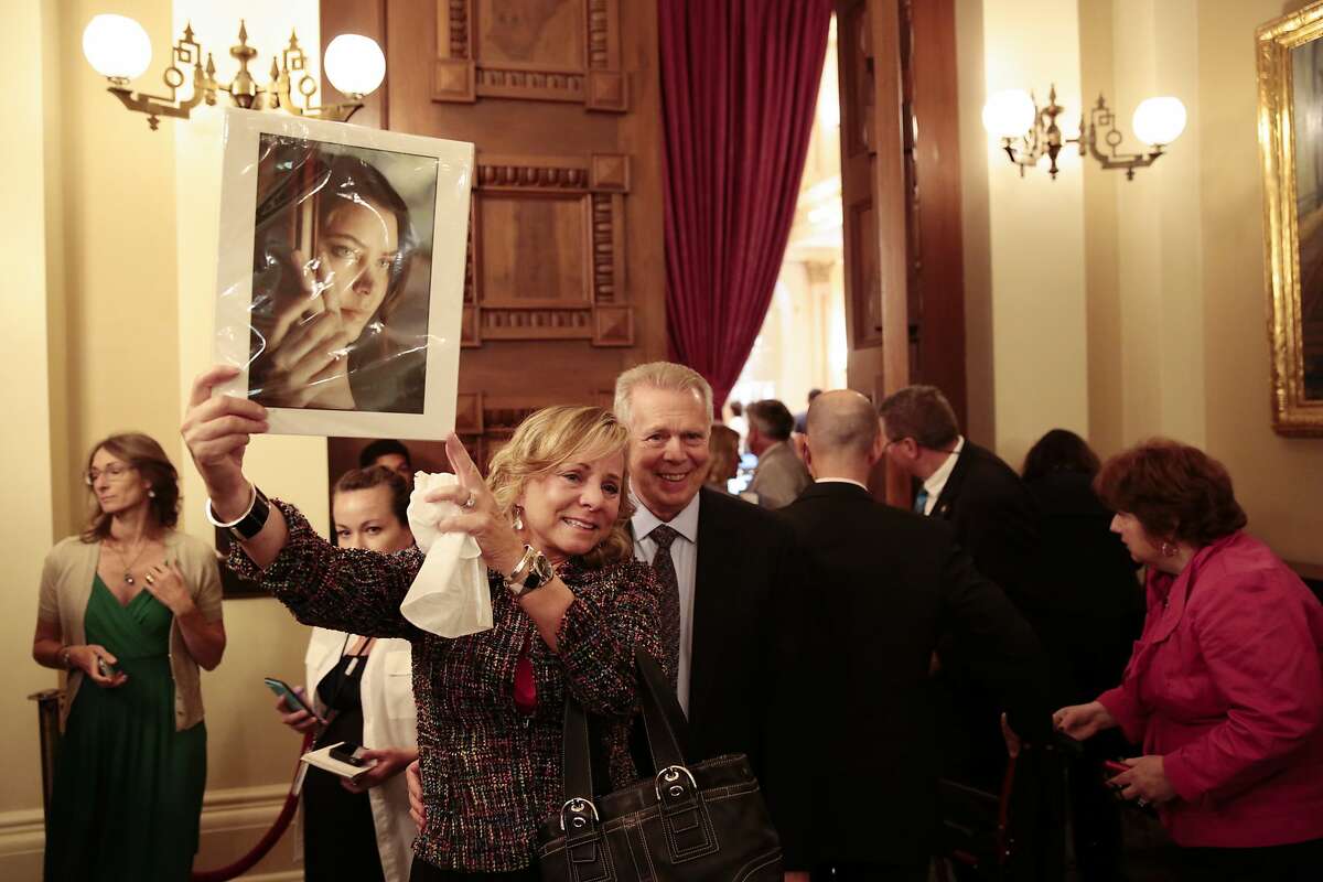 Debbie Ziegler holds a picture of her late daughter, Brittany Maynard, who moved to Oregon after receiving a diagnosis of terminal cancer so she could end her life on her own terms, with Gary Holme, her husband, after hearing the End of Life Option Act was passed at the California State Capitol in Sacramento, Sept. 11, 2015. In a landmark victory for supporters of assisted suicide, the California State Legislature on Friday approved a bill that would allow doctors to help terminally ill people end their own lives. (Ramin Rahimian/The New York Times)