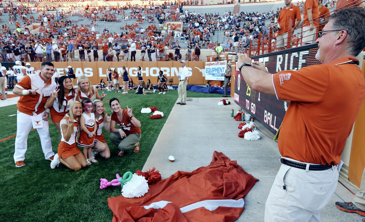 Scott Willingham, Vice President & General Manager Longhorn IMG Sports Marketing, (right) photographs Jennifer S. Mueller, HEB Senior Marketing Manager, and her daughter Remi Mueller, 4, with Texas Longhorns Cheerleaders before the Texas and Rice football game at Texas Memorial Stadium Saturday Sept. 12, 2015 in Austin, Tx.
