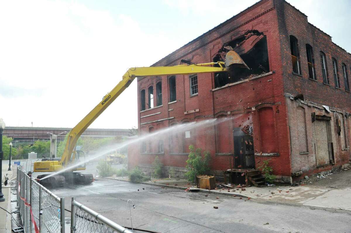 Demolition crews work on knocking down the building at 32 Spencer St. on Sunday, Sept. 13, 2015, in Albany, N.Y. The building was damaged by fire on Saturday. (Paul Buckowski / Times Union)