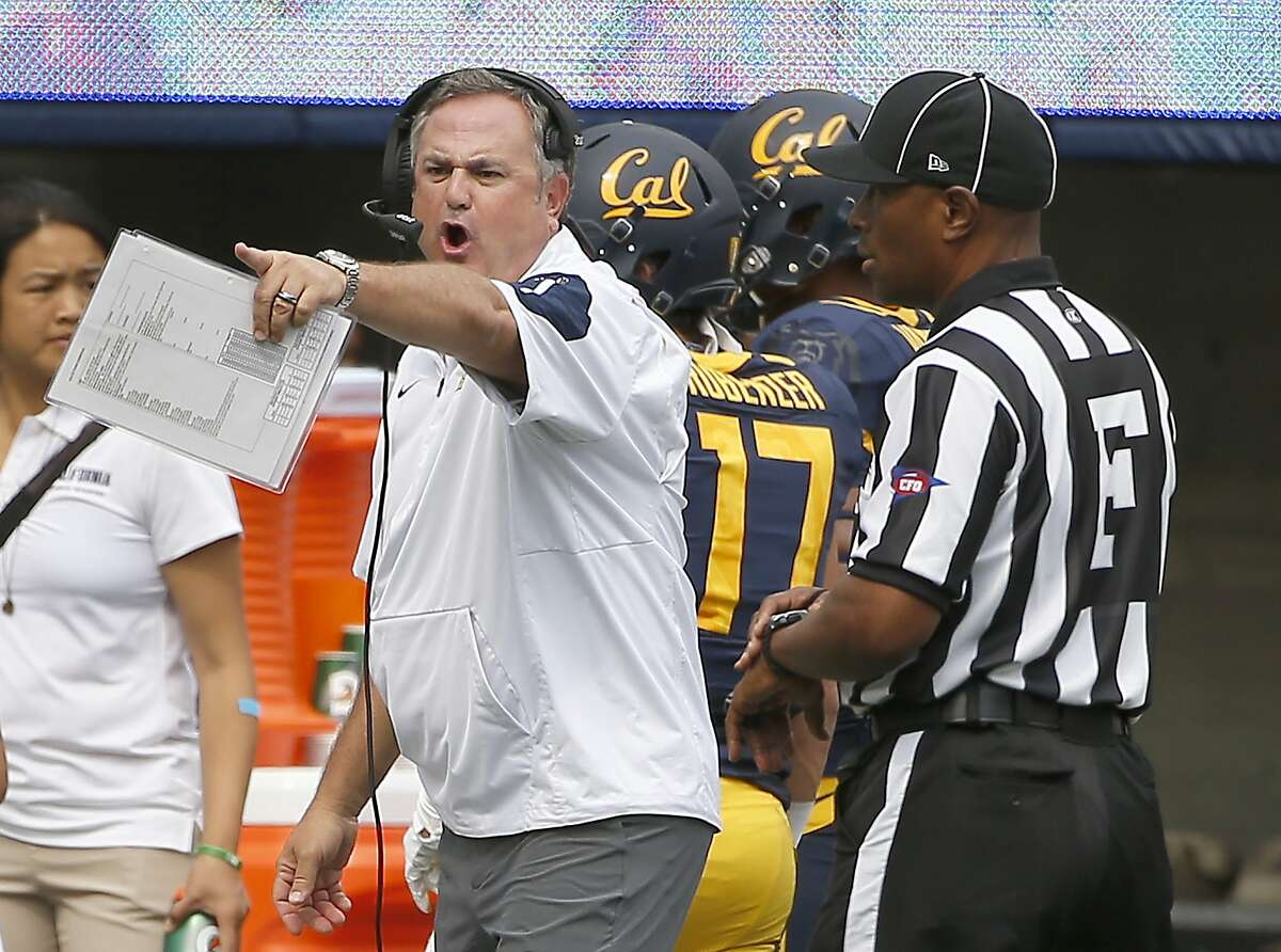 California head coach Sonny Dykes, center, argues a call with the referee during the first half against San Diego State of an NCAA college football game Saturday, Sept. 12, 2015, in Berkeley, Calif. (AP Photo/Tony Avelar)