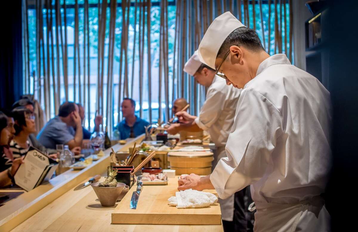Chefs Ingi Son, front, and Jackson Yu make sushi