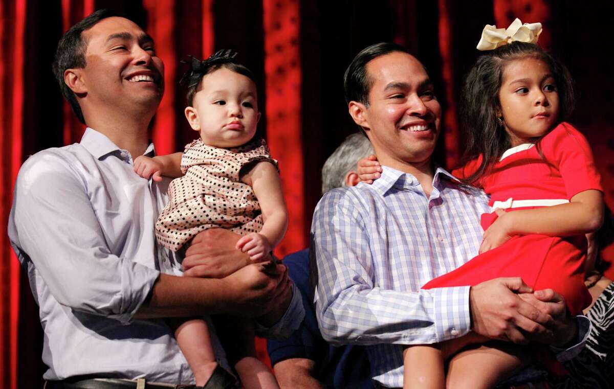 U.S. Rep. Joaquin Castro, D-San Antonio, (from left) with his daughter Andrea Elena and his twin brother HUD Secretary Julián Castro with his daughter Carina are all smiles during their 40th birthday celebration Sept. 15, 2014, at the Tobin Center for the Performing Arts.