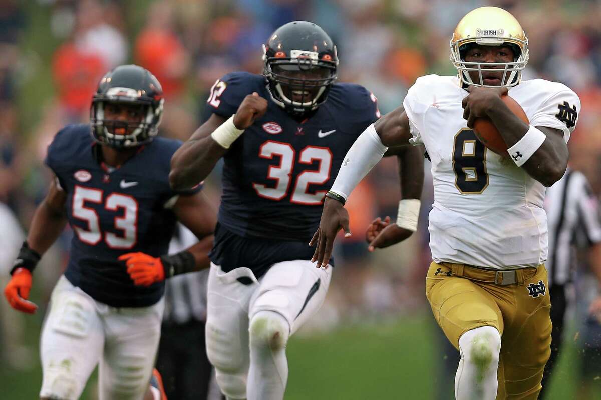 CHARLOTTESVILLE, VA - SEPTEMBER 12: Quarterback Malik Zaire #8 of the Notre Dame Fighting Irish rushes past defensive end Mike Moore #32 of the Virginia Cavaliers in the third quarter at Scott Stadium on September 12, 2015 in Charlottesville, Virginia. The Notre Dame Fighting Irish won, 34-27. (Photo by Patrick Smith/Getty Images) ORG XMIT: 567728715