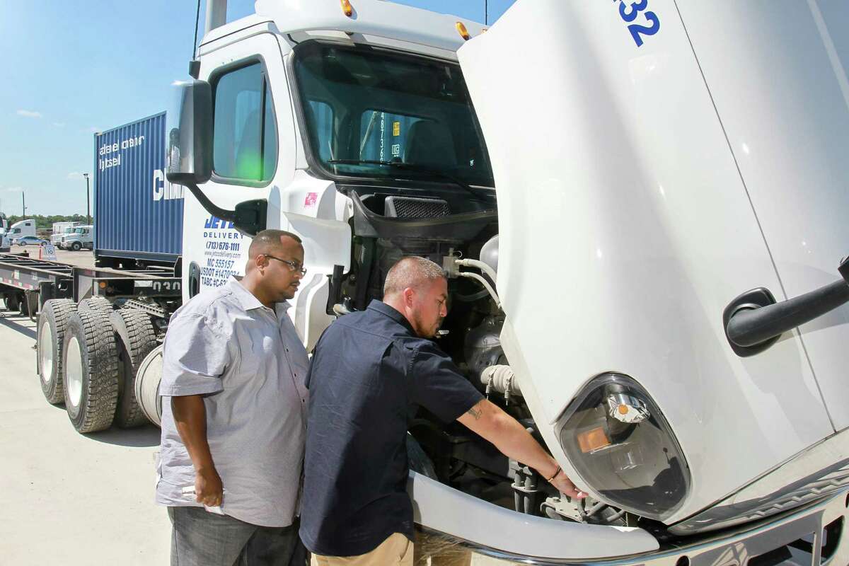 Stafford Wilson, left, a driver advocate, and Julian Leal, a driver, both for Jetco Delivery, consult during a pre-trip inspection. ﻿