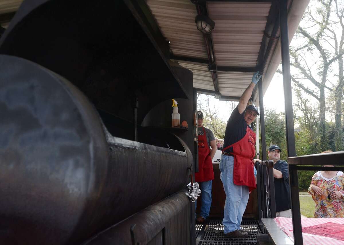 Brad Klein flips a switch to open the hatch of a smoker outside the McFaddin-Ward House visitors center Thursday. Daniel Vaughn, barbecue editor for Texas Monthly, spoke Thursday afternoon at the McFaddin-Ward House about the history of Texas barbecue. Photo taken Thursday 3/19/15 Jake Daniels/The Enterprise