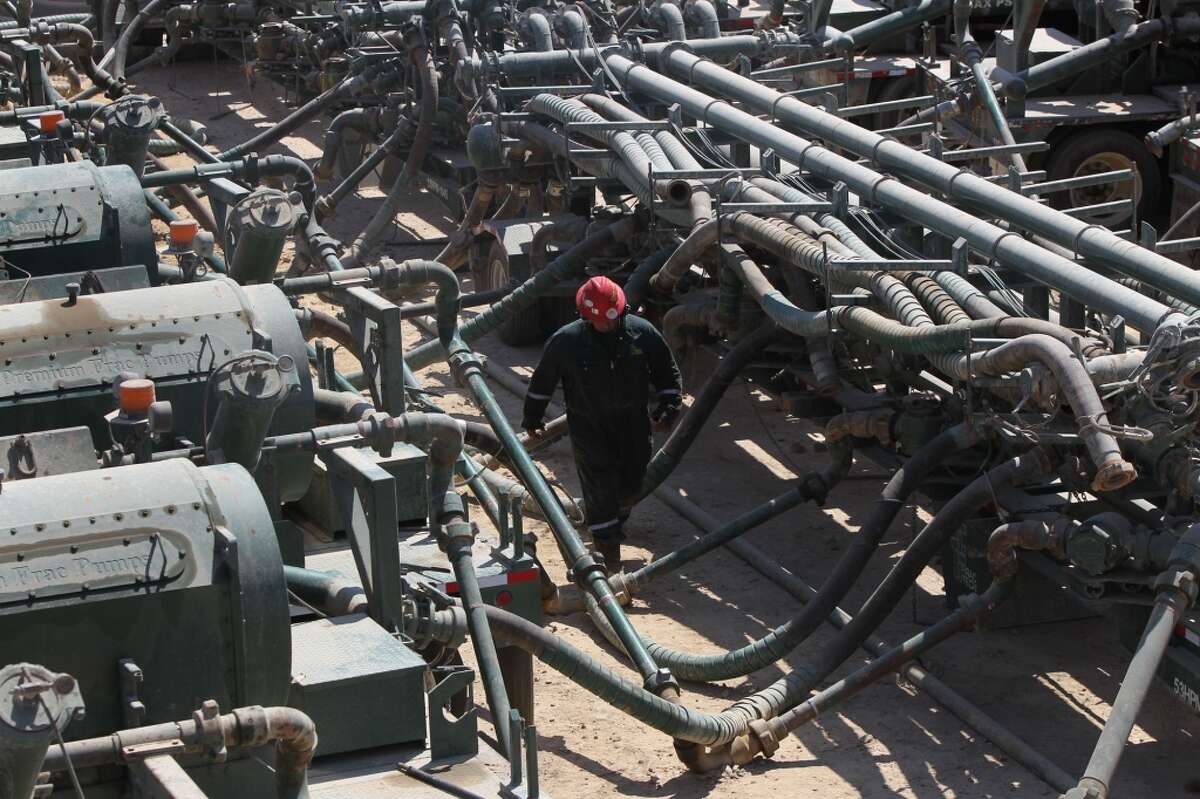An oil worker walks past fracking equipment and pumps at a Chesapeake Energy operation near Carrizo Springs, Texas, in 2011.