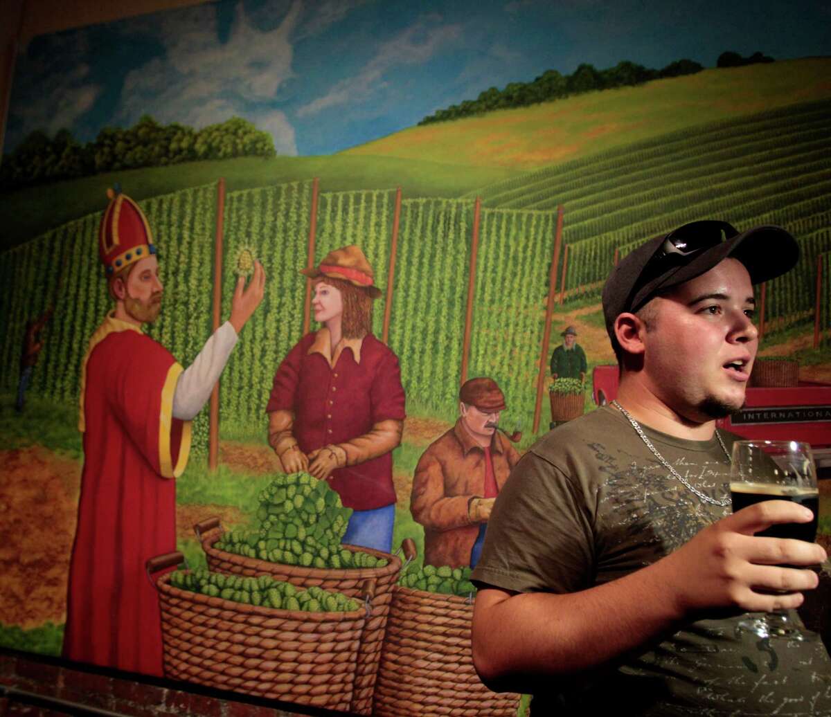 Dale Edwards drinks the first beer ever sold at Saint Arnold Brewing Co. in Houston, on June 18, 2013, following a change in state law. Craft brewers hope to one day be allowed to sell their beer on site to go, as well. (Billy Smith II / Chronicle)