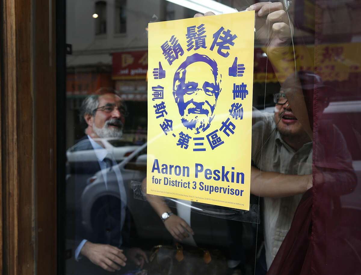 Aaron Peskin looks on as Alan Leong tapes a campaign poster inside his music shop on Jackson Street in Chinatown in San Francisco, Calif. on Thursday, Sept. 17, 2015. Peskin is seeking to unseat incumbent Julie Christensen in District 3 on the Board of Supervisors, a position he previously held from 2001-2009.