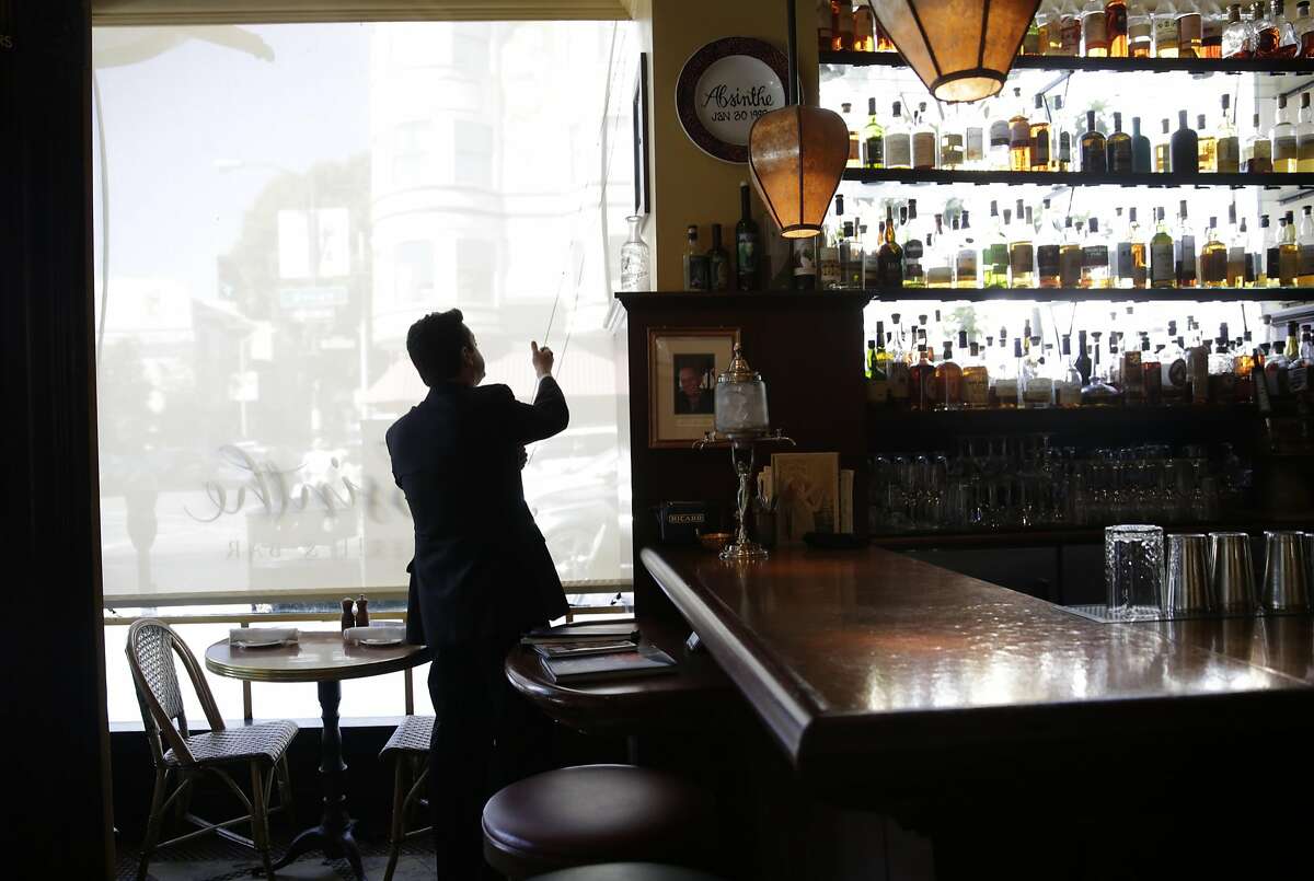 Trevor Noonan, floor manager, raises window coverings the morning after an employee unexpectedly quit while working at Absinthe Brasserie and Bar on Friday, September 18, 2015 in San Francisco, Calif.