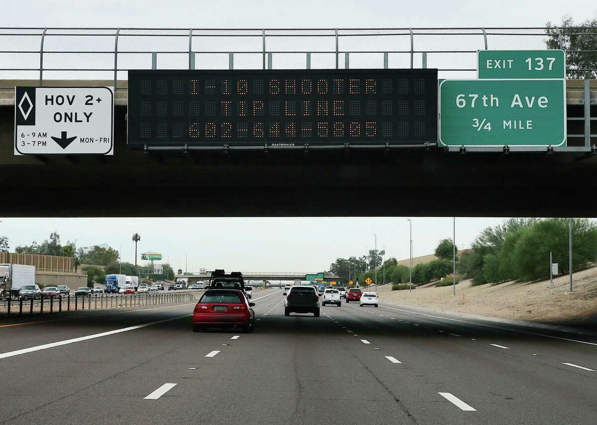 FILE - In this Sept. 10, 2015, file photo, a tip line for motorist hangs on a freeway sign along Interstate 10, in Phoenix. A suspect has been arrested in a string of shootings along Phoenix-area freeways that have kept drivers on edge, state officials said Friday, Sept. 18. (AP Photo/Matt York, File)