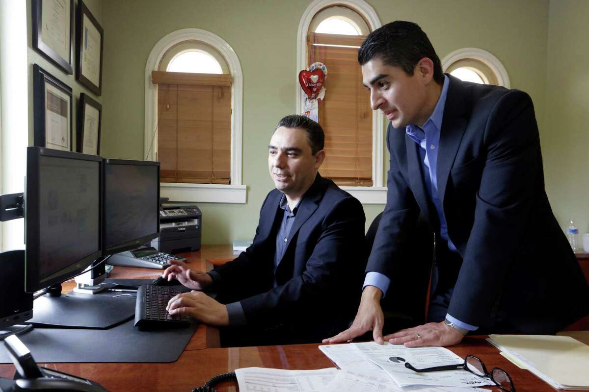 In this Friday, Aug. 21, 2015 photo, certified financial planners Aaron Munoz, left, and Gilbert Cerda, pose for a photo at their offices in Downey, Calif. Their company, Cerda Munoz Advisors, offers financial advice with a focus on the Hispanic population. (AP Photo/Damian Dovarganes)