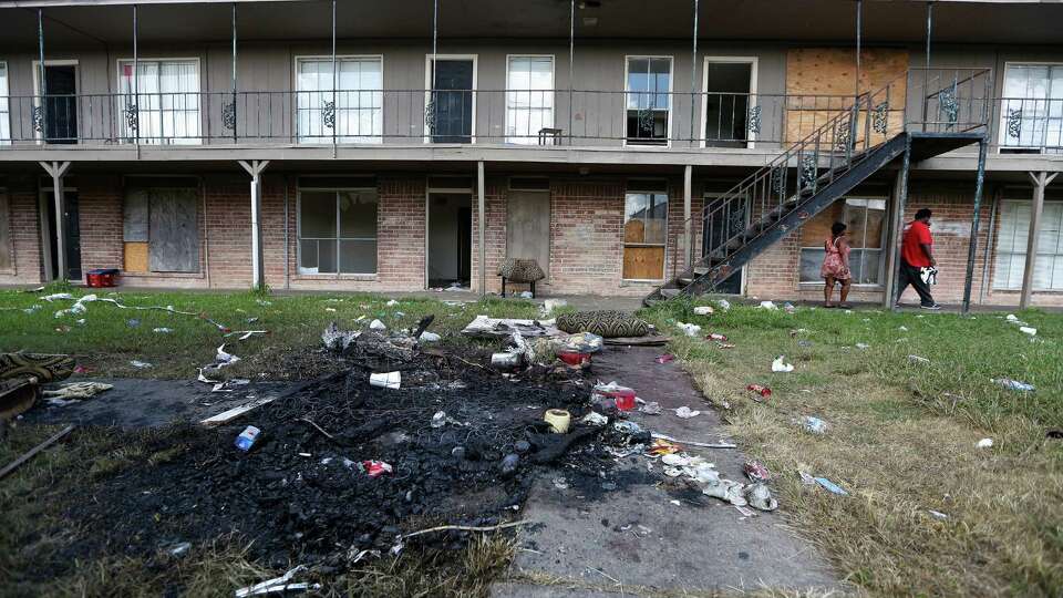 The remains of a mattress fire and trash in the courtyard of the Crestmont Apartments 5602 Selinsky Road Friday, Sept. 18, 2015, in Houston. Mayor Parker held a news conference Thursday to announce the city is intervening to help the residents of the rundown Crestmont Apartments on Selinsky at Martin Luther King Drive. The tenants have been without power because the landlord has refused to pay the bill. This has created a public safety emergency for the residents. The City is arranging to get the power turned back on and has asked the Red Cross to help with food and water for the time being. The City is working to find new housing for the tenants.