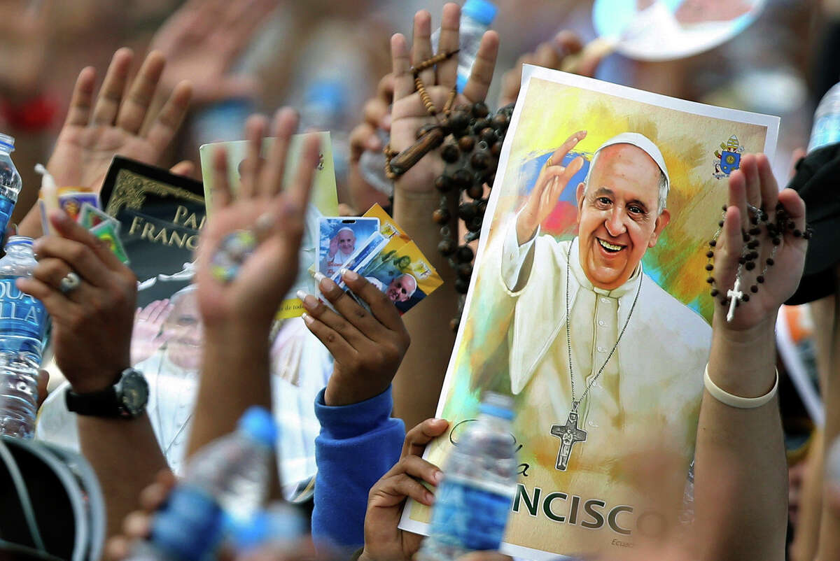 Pilgrims hold up their hands to be blessed by Pope Francis during a Mass in Guayaquil, Ecuador. Latin America's first pope is due to arrive in the United States on Tuesday.