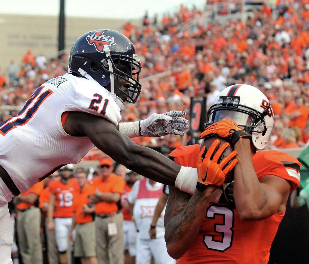 Oklahoma State wide receiver Marcell Ateman (right) catches a 13-yard touchdown pass in front of UTSA cornerback Bennett Okotcha during Saturday’s game in Stillwater, Oklahoma. The 55-point loss was the worst in program history.