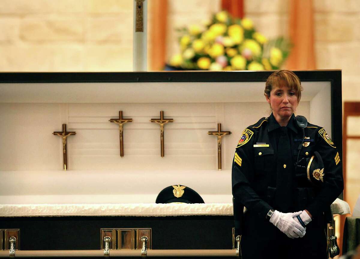 Standing in front of her husband's casket, Bexar County Sheriff’s Deputy Sgt Yvonne Vann waits to greet fellow officers and friends before funeral services for her husband, Sgt. Kenneth Vann of the Bexar County Sheriff’s Office, at St. Joseph of Honey Creek Catholic Church in Spring Branch on June 3, 2011.