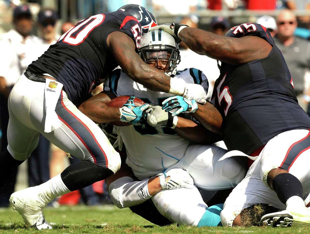 Panthers fullback Mike Tolbert, center, is stopped by Texans inside linebacker Akeem Dent, left, and nose tackle Vince Wilfork. Tolbert carried five times for 31 yards.