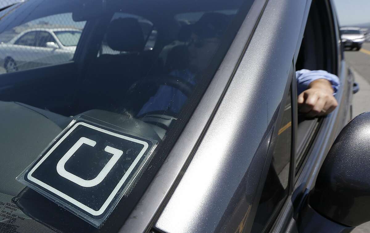 In this July 15, 2015 file photo, Uber driver Karim Amrani sits in his car parked near the San Francisco International Airport parking area in San Francisco. Hilton is hailing the ride sharing service Uber to help guests reach its hotels and then explore the city where they are staying, the companies announced Tuesday, Sept. 1, 2015. (AP Photo/Jeff Chiu, File)