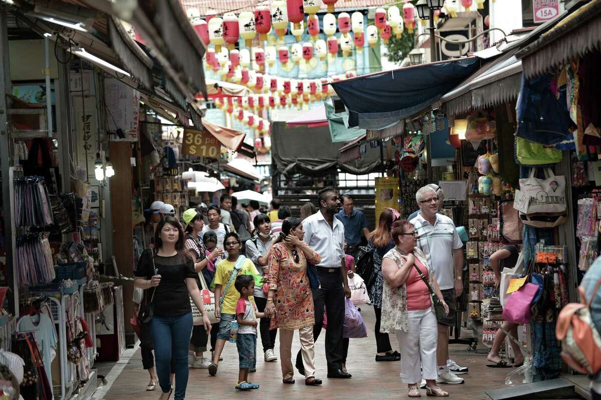 People walk through the Chinatown street in Singapore on October 14, 2014.