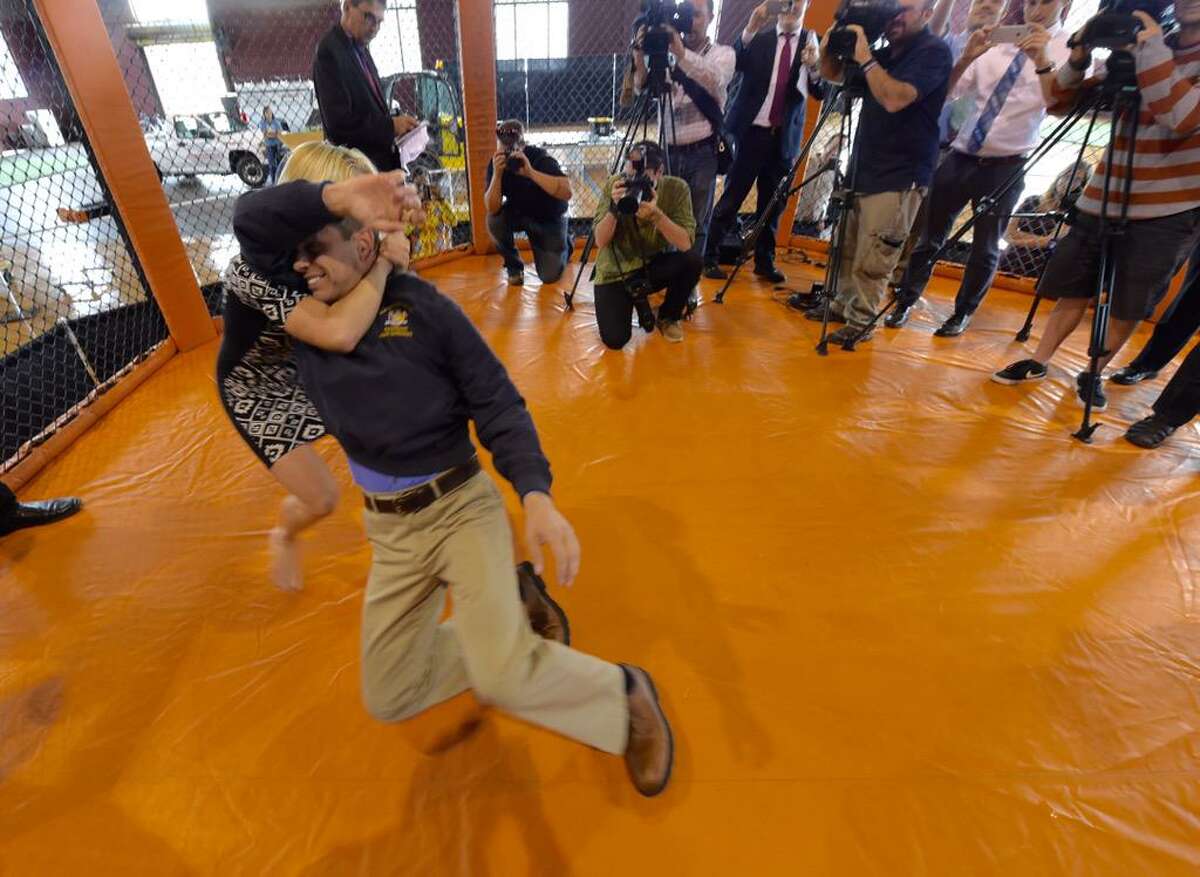 Assemblyman Angelo Santabarbara, D-Rotterdam, is taken to the mat by a mother of three during a demonstration of mixed martial arts at the Schenectady Armory on Washington Avenue. The armory will host an amateur MMA card on Saturday. (Skip Dickstein / Times Union)