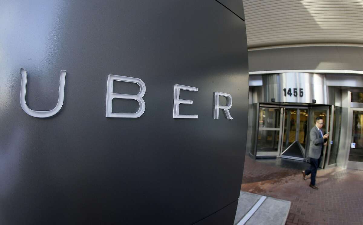 FILE - In this Dec. 16, 2014, file photo a man leaves the headquarters of Uber in San Francisco. (AP Photo/Eric Risberg, File)
