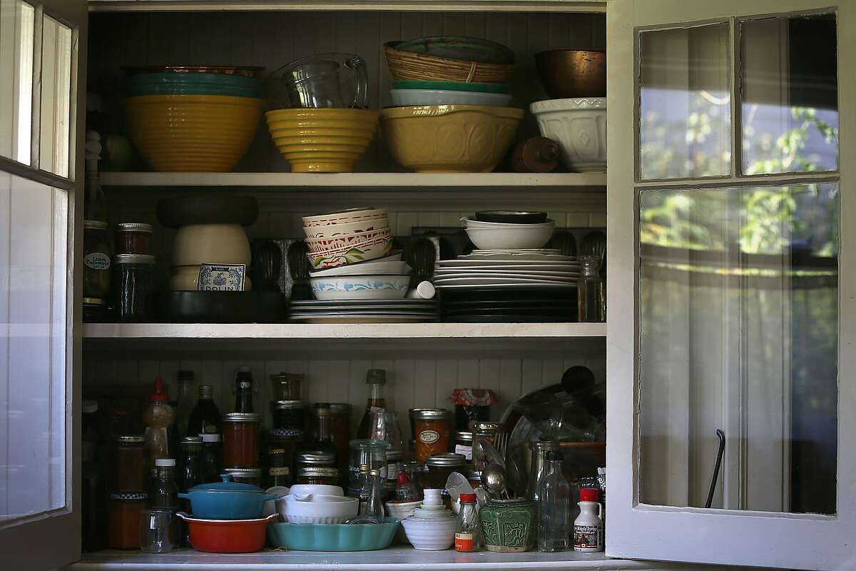 Writer Dana Velden shows her inset kitchen cabinet holding all her treasures in the kitchen at home in Oakland, Calif., on Monday, September 21, 2015.