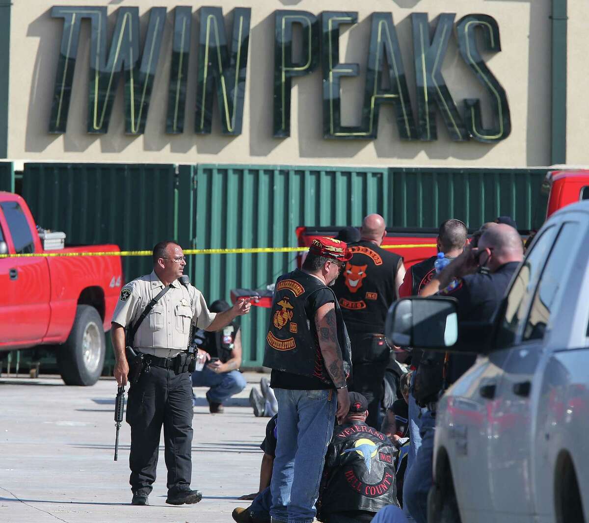 FILE - In this May 17, 2015 file photo, authorities investigate a shooting in the parking lot of the Twin Peaks restaurant in Waco, Texas. Police shot bikers in the deadly shootout that erupted last spring outside a Texas restaurant, though it remains unclear if their bullets caused any of the nine fatalities, according to evidence reviewed by The Associated Press. (AP Photo/Jerry Larson, File)