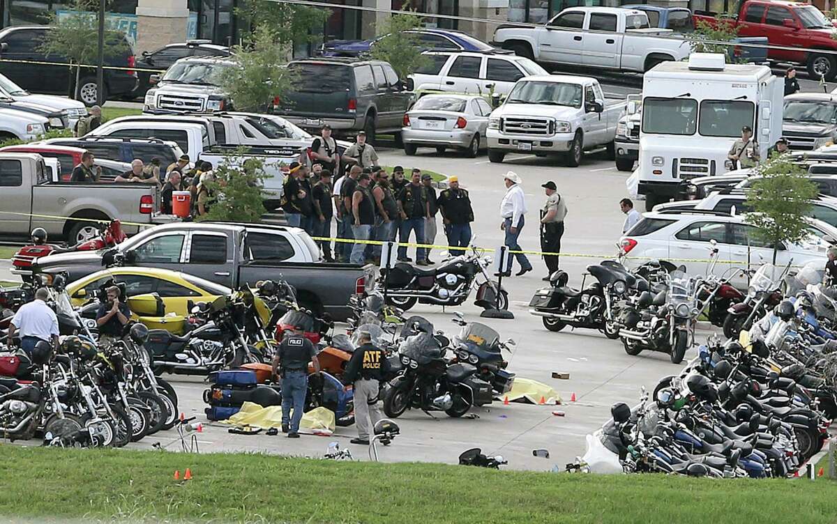 FILE - In this May 17, 2015 file photo, authorities investigate a shooting in the parking lot of the Twin Peaks restaurant, in Waco, Texas. Bikers and public watchdogs have criticized authorities here for how they?’ve handled the shooting investigation, citing the mass arrests of more than 170 people held for days or weeks on $1 million bonds without sufficient evidence to support those arrests four months after the shootings. No formal charges have been made, and it remains unclear whose bullets, including police bullets, struck the dead and injured, or when cases will be presented to a grand jury, which is currently led by a Waco police detective. (AP Photo/Jerry Larson, File)
