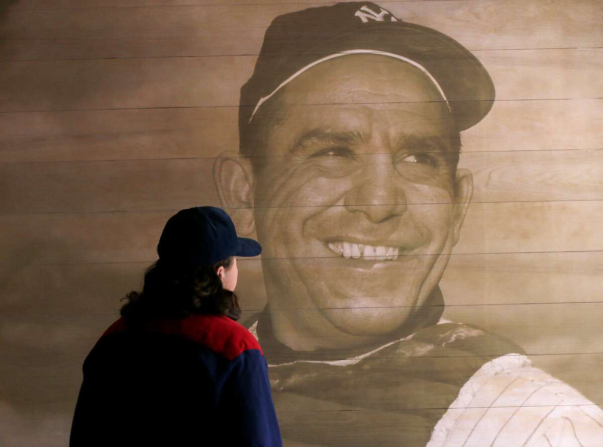T.J. Hitchings, of Plainsboro, N.J., looks at a portrait of former New York Yankees hall of fame catcher Yogi Berra at the Yogi Berra Museum, Wednesday, Sept. 23, 2015, in Little Falls, N.J. Berra died Tuesday at the age of 90. (AP Photo/Julio Cortez)