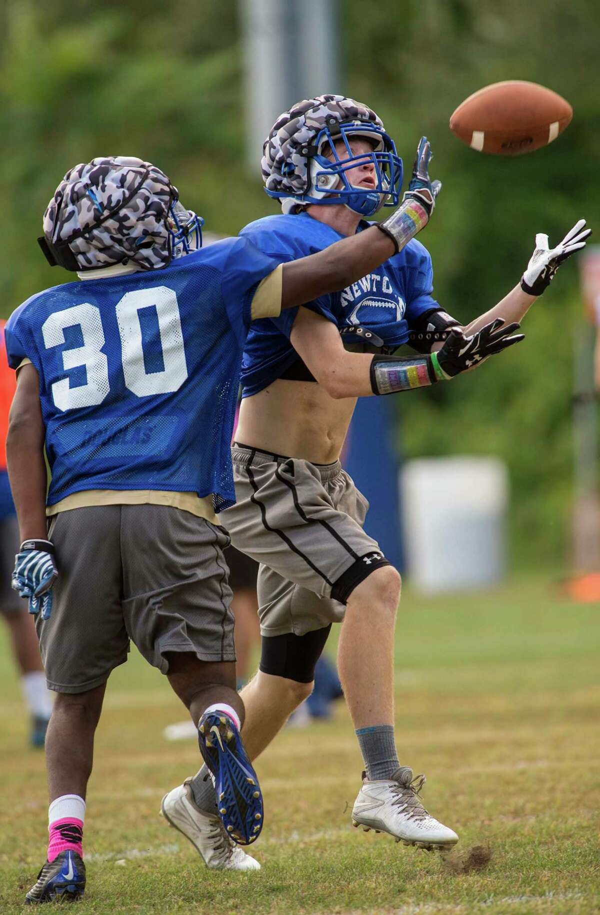 Newtown High SchoolâÄôs Hunter Cobb (30) and Ethan Carpenter battle for the ball during a drill at football practice held at Newtown High School, Newtown, CT on Thursday, August 20, 2015.