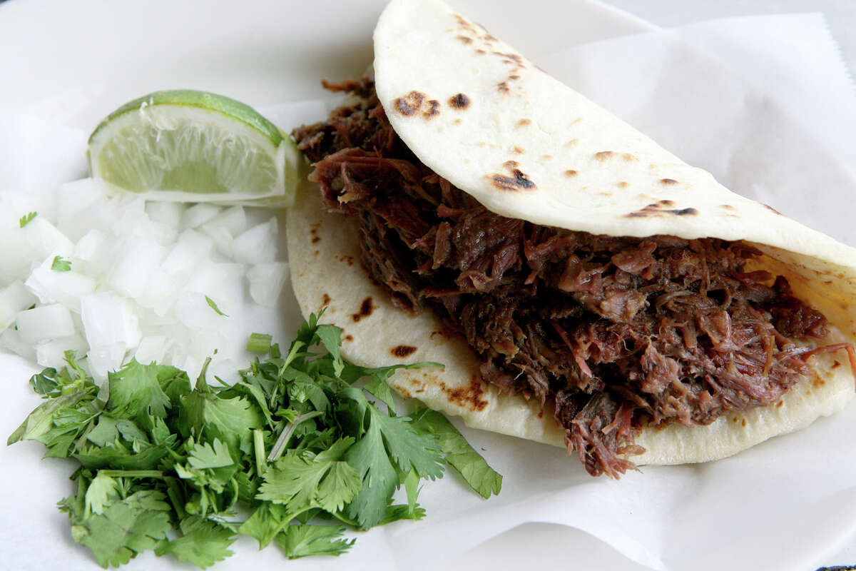 A barbacoa taco at El Milagrito includes minced cilantro, diced onions and a wedge of lime.