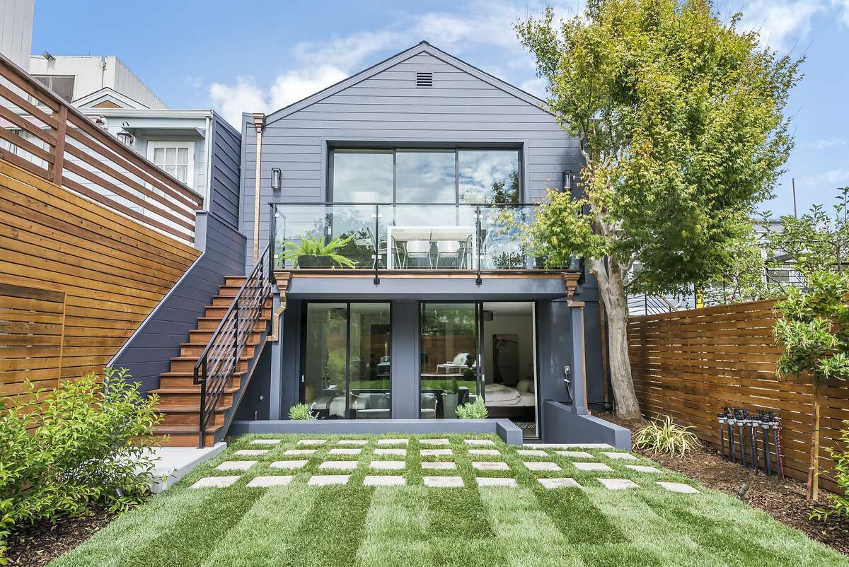 The south-facing backyard of 121 Clipper St. in Noe Valley includes a level lawn, a shade tree, raised deck and a patio.