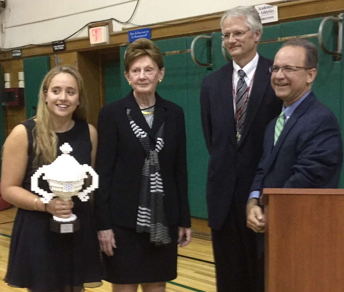 Greenwich High School junior Olivia Hallisey, left, with her Google Science Fair Grand Prize trophy, at the Board of Education’s meeting Thursday at Julian Curtiss School. Joining Hallisey at the podium were, from left, Board of Education Chairman Barbara O’Neill; Superintendent of Schools William McKersie; and Andrew Bramante, Hallisey’s honors science research teacher.