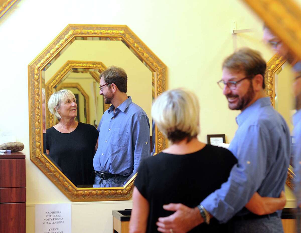 "A lot of marriages don't last this long," said Peter Scifo, right, as his photo was being taken with Liz Gray, co-owners of Trendsetters Salon, who are celebrating being in business for 30 years, in their salon at 932 Hope Street in Stamford, Conn., Wednesday, Sept. 2, 2015.